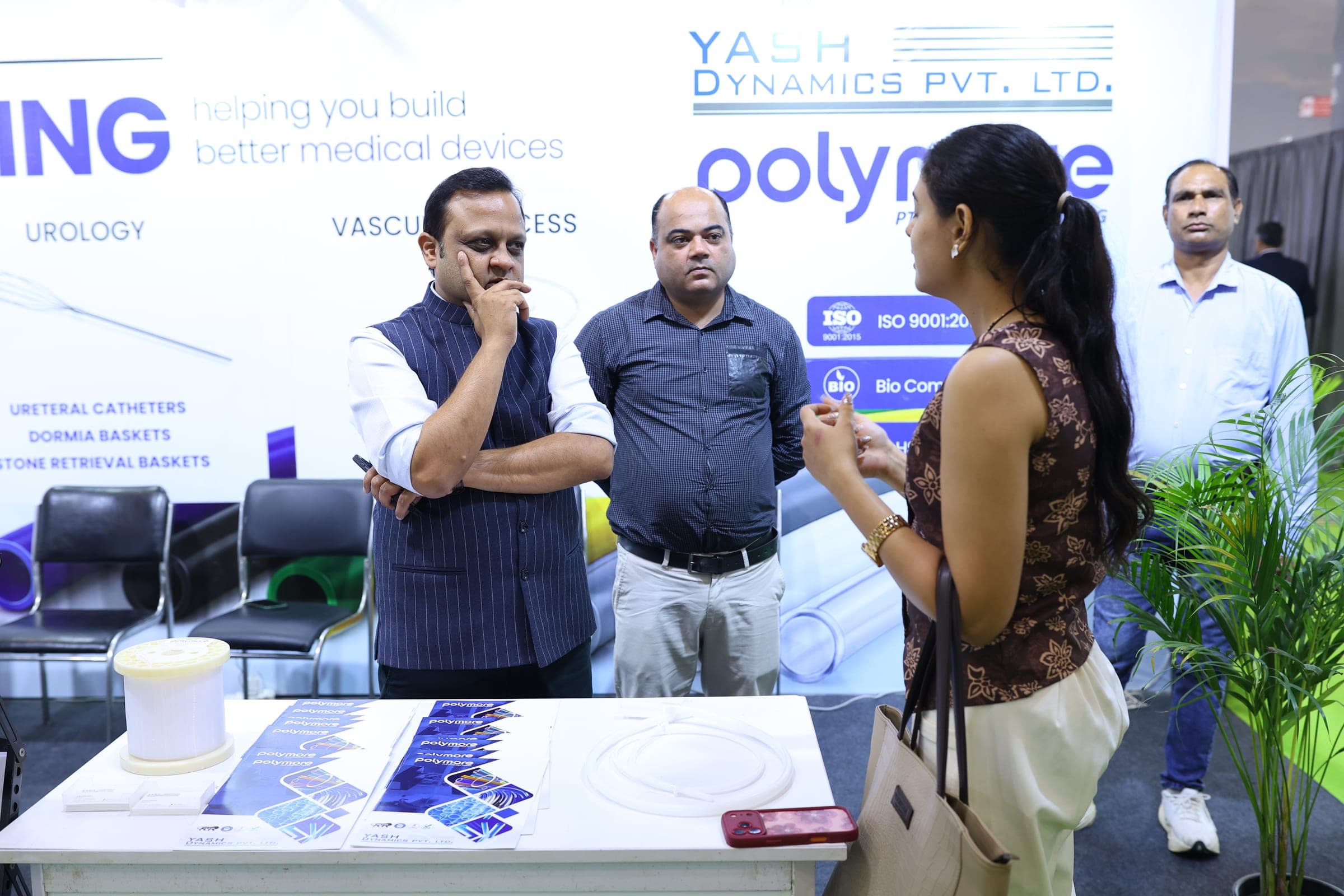 Yash Dynamics team discussing Polymore PTFE tubing with a visitor